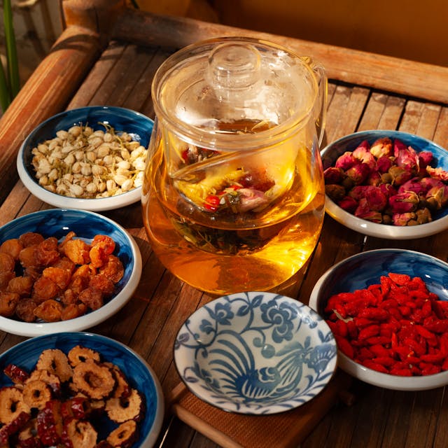 varias hierbas para preparar una infusion. Goji entre otras. Y una jarra de agua lista para prepararla