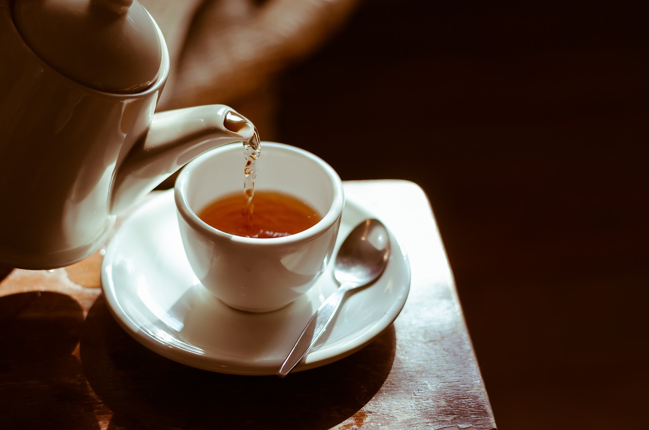 Una tetera que sirve a una taza de te