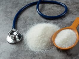 HbA1c y diabetes: ¿siempre refleja bien cómo está nuestra glucosa? Una mesa con una cuchara que contiene azñucar blanca y al lado hay un estetoscopio