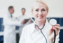 Doctora de medidicina sonriente con un ascultor en la mano.