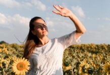 Mujer al sol haciendo visera con las manos