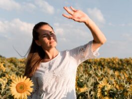 Mujer al sol haciendo visera con las manos