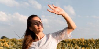 Mujer al sol haciendo visera con las manos