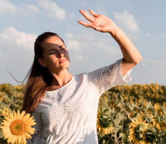 Mujer al sol haciendo visera con las manos