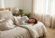 Mujer estirada en la cama de un dormitorio tapada con una manta descansando