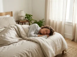 Consejos para tener un sueño reparador Mujer estirada en la cama de un dormitorio tapada con una manta descansando