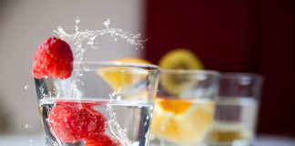 Vasos de agua con frambuesas frescas y rodajas de cítricos, alternativa saludable para hidratarse en personas con diabetes