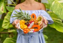 Bandeja sostenida por una mujer joven con frutas exóticas y tropicales, so