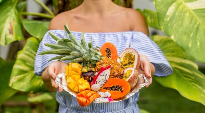 Bandeja sostenida por una mujer joven con frutas exóticas y tropicales, so