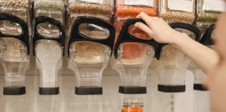 Dispensadores de legumbres, la mano de una chica se ve sirviendose de uno de ellos.