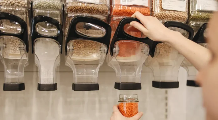 Dispensadores de legumbres, la mano de una chica se ve sirviendose de uno de ellos.