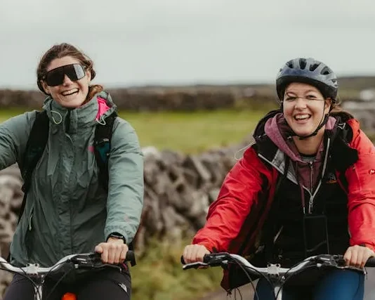 Dos ciclistas en bicicletas de montaña saludan alegremente a la cámara