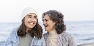 madre e hija sonrientes en un paseo por la playa