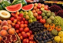 Mercaddo con estantes que muestran frutas de temporada de septieembre.