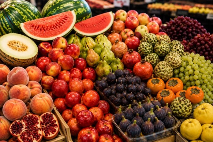 Mercaddo con estantes que muestran frutas de temporada de septieembre.