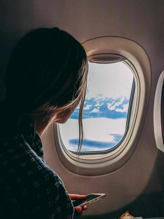 El jet lag y como evitarlo mujer-observa-nubes-ventanilla-avion