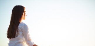 Una mujer meditando en posición de lotus al aire libre