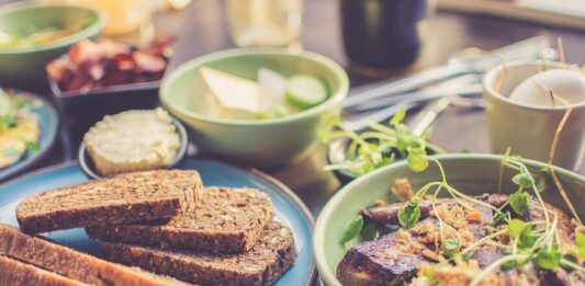 Desayuno saludable para personas con diabetes con tostadas integrales, aguacate, semillas y café en mesa equilibrada