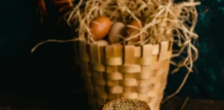 Panes rústicos de avena e integral sobre una mesa de madera con una cesta de huevos