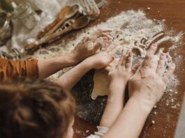 niños en la cocina ayudando a amasar la harina