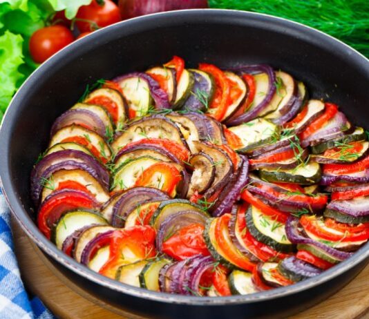 Plato con verduras asdas con calabaciones, berenjenas, pimientos rojos y cebolla y salpicada de tomillo
