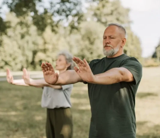 Tai Chi y diabetes: ejercicio suave para moverse mejor y cuidar la glucemia Dos personas adultas practican Tai Chi al aire libre en un parque, una actividad suave y de bajo impacto adecuada para mejorar equilibrio y movilidad.